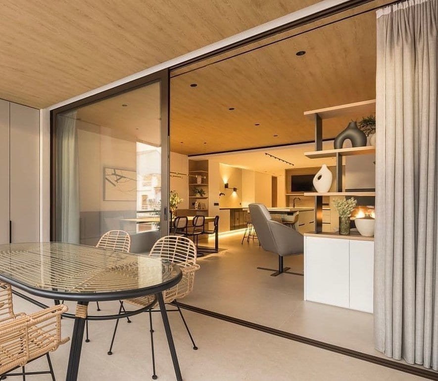 Balconera corredera de aluminio de grandes dimensiones abierta a una terraza