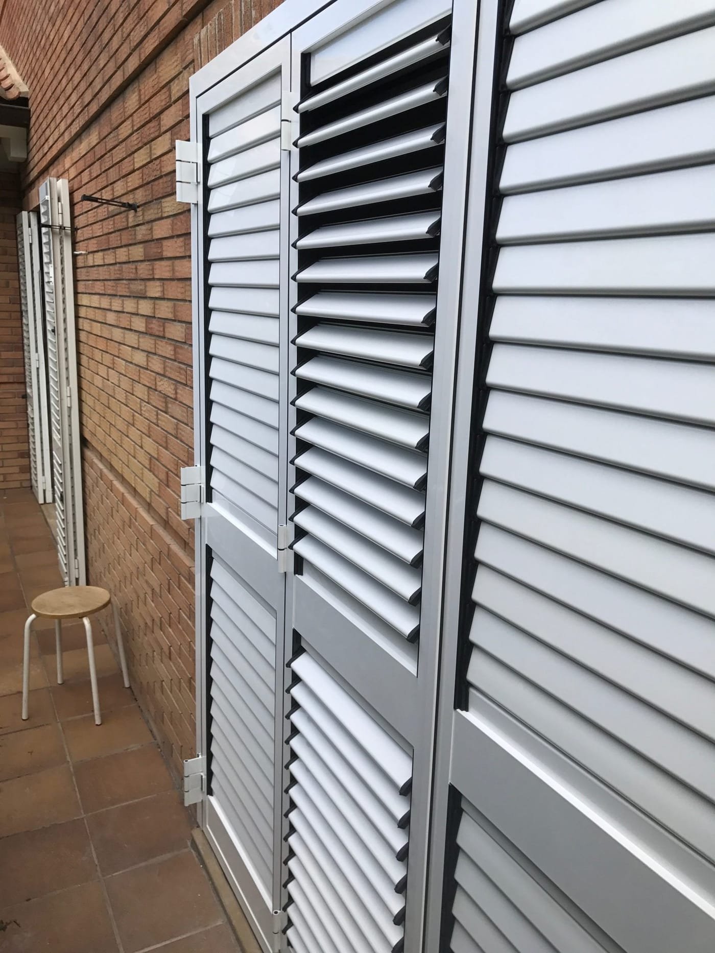 Cerramiento de aluminio con mallorquinas de lamas instalado en una terraza
